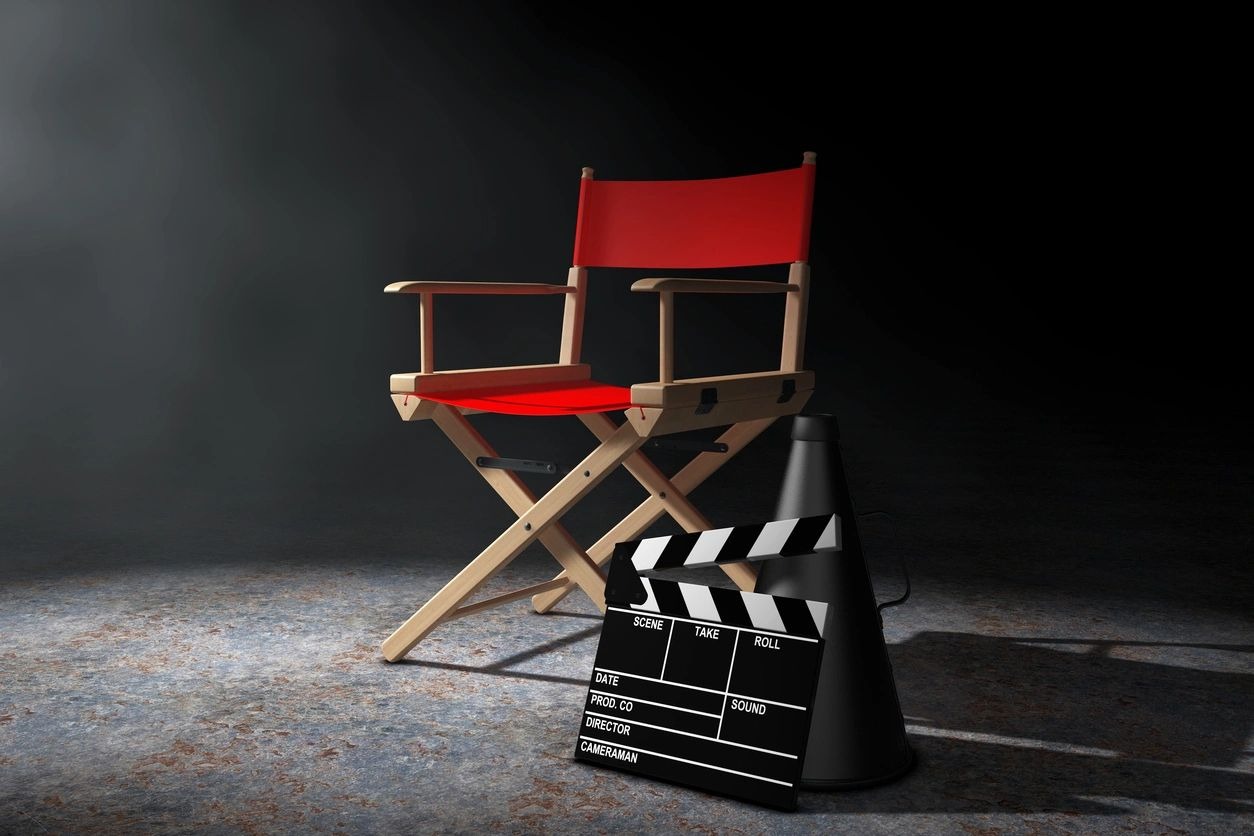 Red Director Chair, Movie Clapper and Megaphone in the volumetric light on a black background